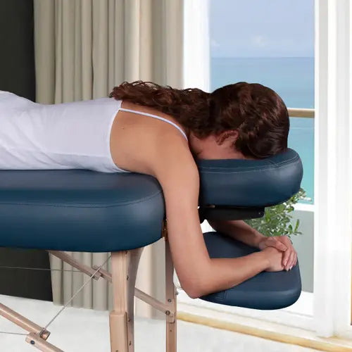 A black padded massage table with a pair of matching leather side arm rest extensions attached to the frame to widen the upper body area.