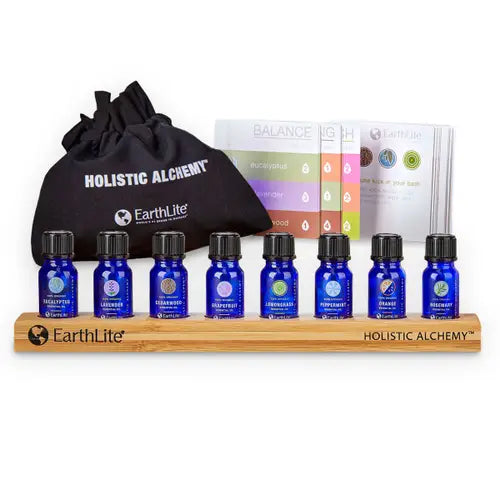A relaxing spa display featuring a collection of amber glass essential oil bottles alongside a folded fabric herbal comfort pack filled with dried lavender.