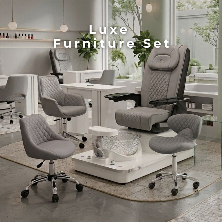 Luxe nail salon furniture set featuring a grey quilted pedicure spa chair with glass basin, matching manicure table, and rolling technician stools.