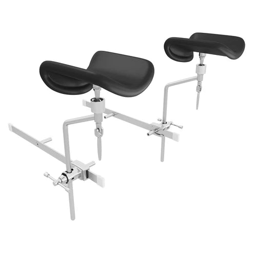 Pair of medical table stirrups with integrated rail mounting system, adjustable stainless steel frame, and ergonomic black padded cushions for patient comfort.