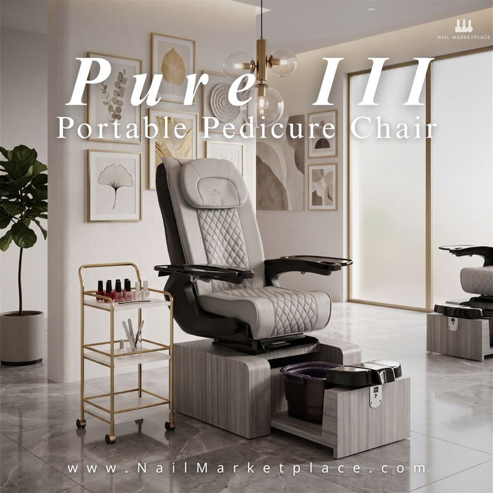 Pure III Portable Pedicure Chair in grey quilted upholstery with a pull-out foot basin, displayed next to a gold salon cart by Nail Marketplace.