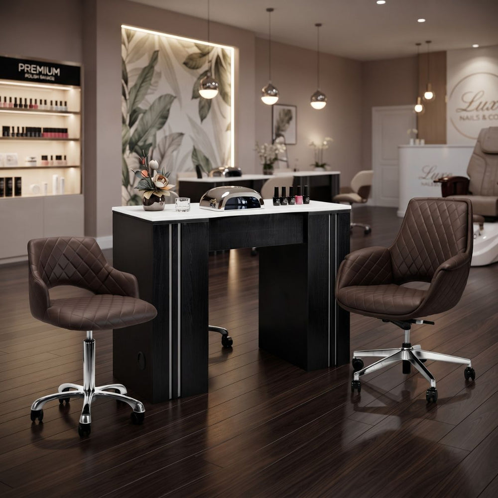 Modern black manicure table with white top and brown quilted rolling salon chairs.