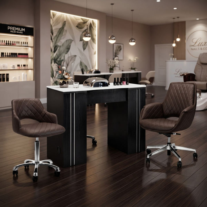Modern black manicure table with white top and brown quilted rolling salon chairs.