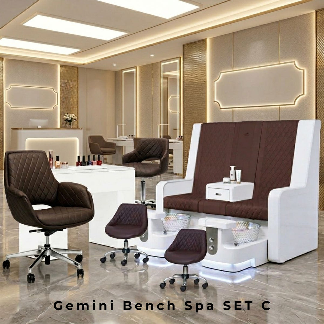 Modern double pedicure bench spa station with dark brown quilted leather seats, white frames, integrated glass sinks, and low technician stools.