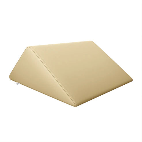 Beige DIR triangular massage wedge bolster for salon and spa tables.